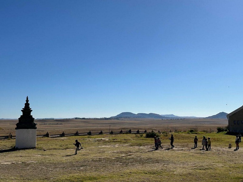 Trẻ mồ côi chơi bóng đá bên bảo tháp Phật giáo tại Trung tâm chăm sóc Amitofo ở Lesotho. Ảnh của Raymond Lam