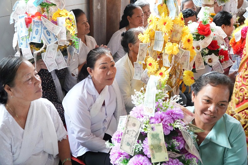 Người phụ nữ Khmer c&ugrave;ng nhau tụ họp, người kết hoa, người d&aacute;n những tờ tiền c&ocirc;ng đức l&ecirc;n c&acirc;y b&ocirc;ng với tất cả l&ograve;ng th&agrave;nh k&iacute;nh.