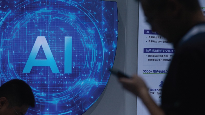 Kh&aacute;ch tham dự hội chợ đứng trước biển hiệu về Tr&iacute; tuệ Nh&acirc;n tạo (AI) tại Hội nghị Tr&iacute; tuệ Nh&acirc;n tạo Thế giới ở Thượng Hải v&agrave;o ng&agrave;y 27 th&aacute;ng 7 năm 2025. (Ying Tang/NurPhoto via Getty Images)