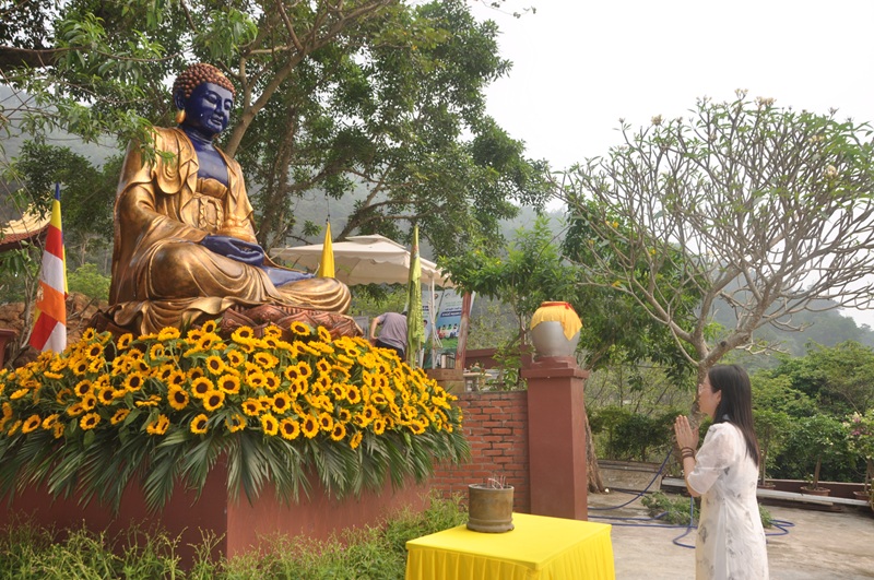 Nh&agrave; thiết kế &aacute;o d&agrave;i cao cấp Nghi&ecirc;m L&ecirc; th&agrave;nh t&acirc;m khấn nguyện trước gian thờ Phật v&agrave; khi đảnh lễ t&ocirc;n tượng đức Phật Dược Sư 