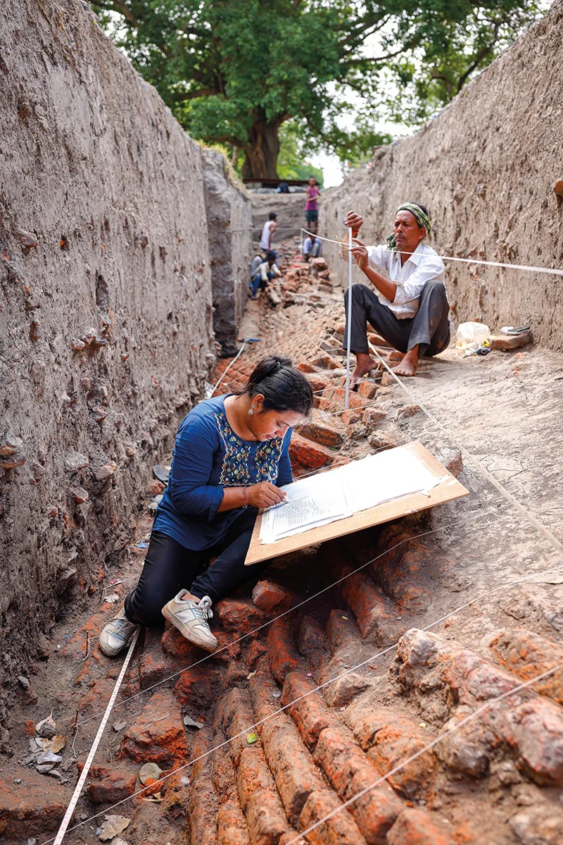 Kỹ sư Roshani Maharjan, c&ocirc;ng t&aacute;c tại Cục Khảo cổ Nepal, ghi ch&eacute;p hiện trường khai quật. (Ảnh: GMB Akash / Panos Pictures)
